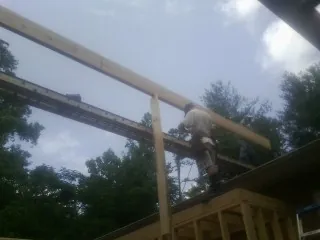 Carpenter setting a ridge beam over a new addition frame — Ice Dam Removal by Roofing Brothers in Hoboken