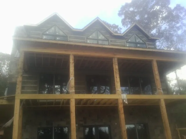 Dormers and porch framing on a large log home under construction — Roof Coating work by our crew in Hoboken