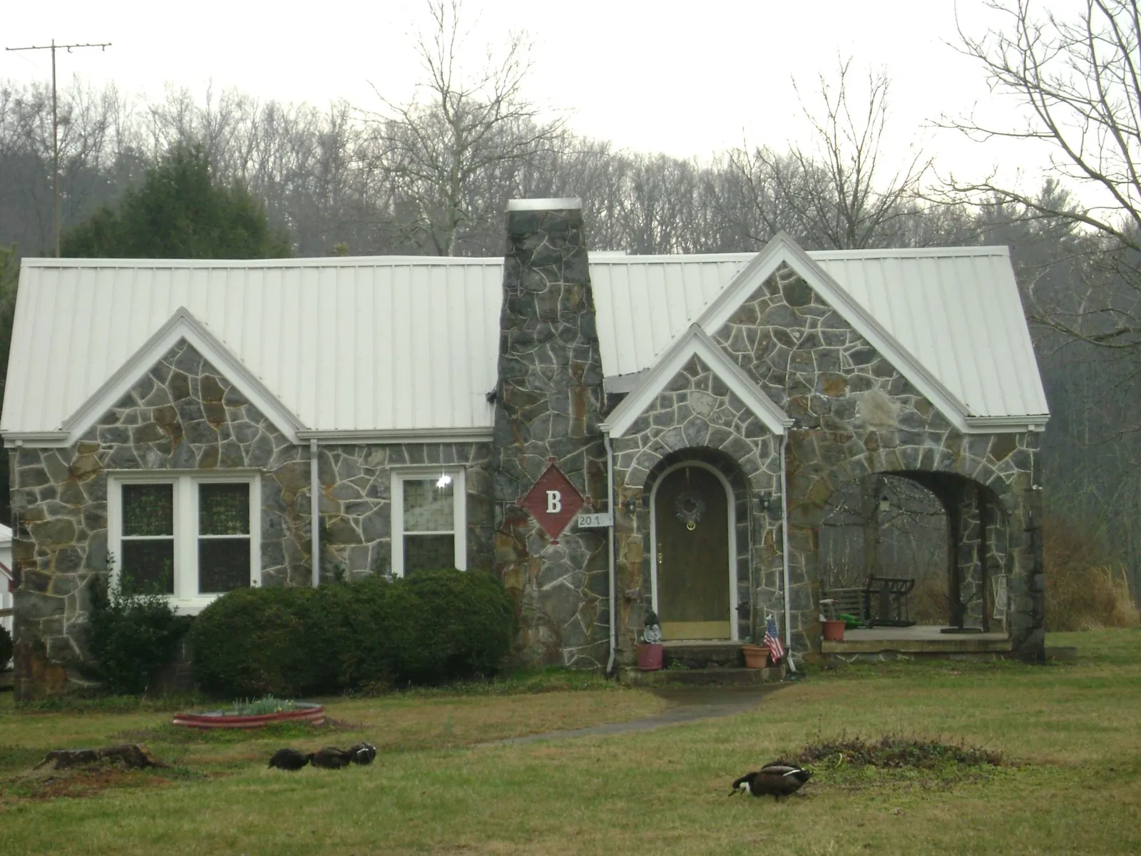 White metal roof on a stone cottage with steep gables in Hoboken