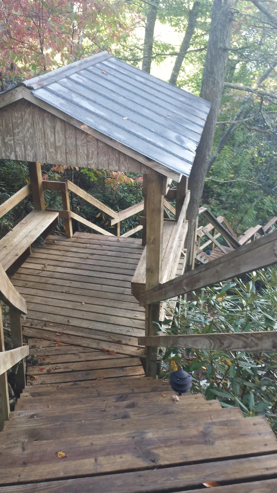 Metal roofed shelter over wooden steps on a wooded walkway — Skylight Repair & Installation work by our crew in Hoboken